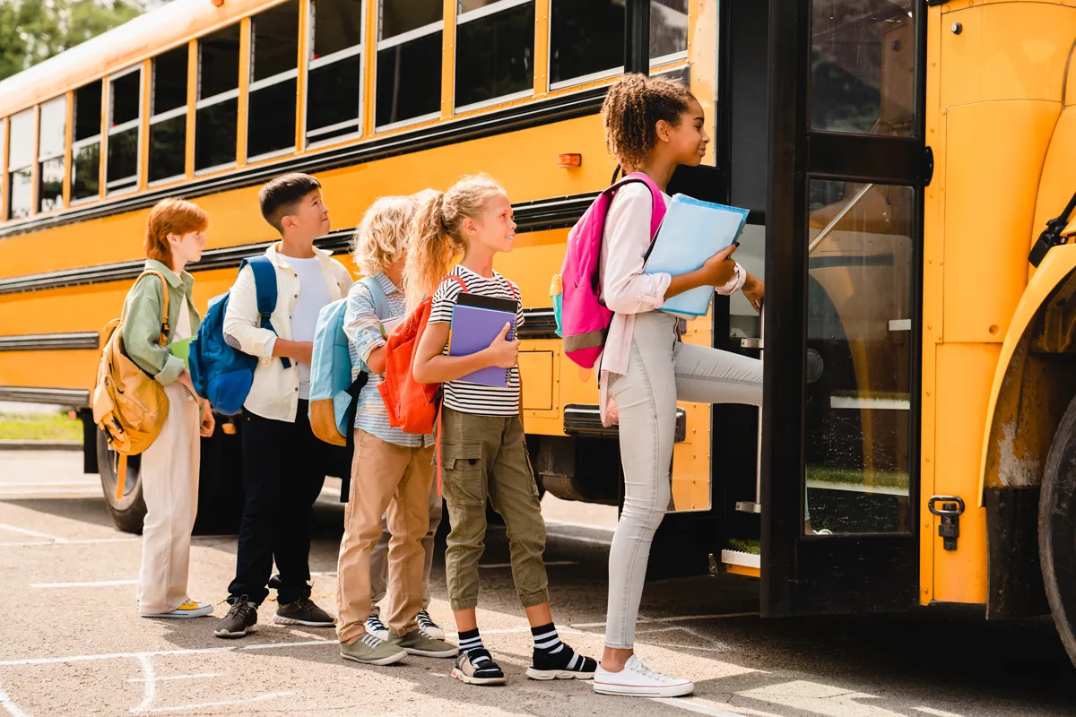 middle school kids in line to get on school bus