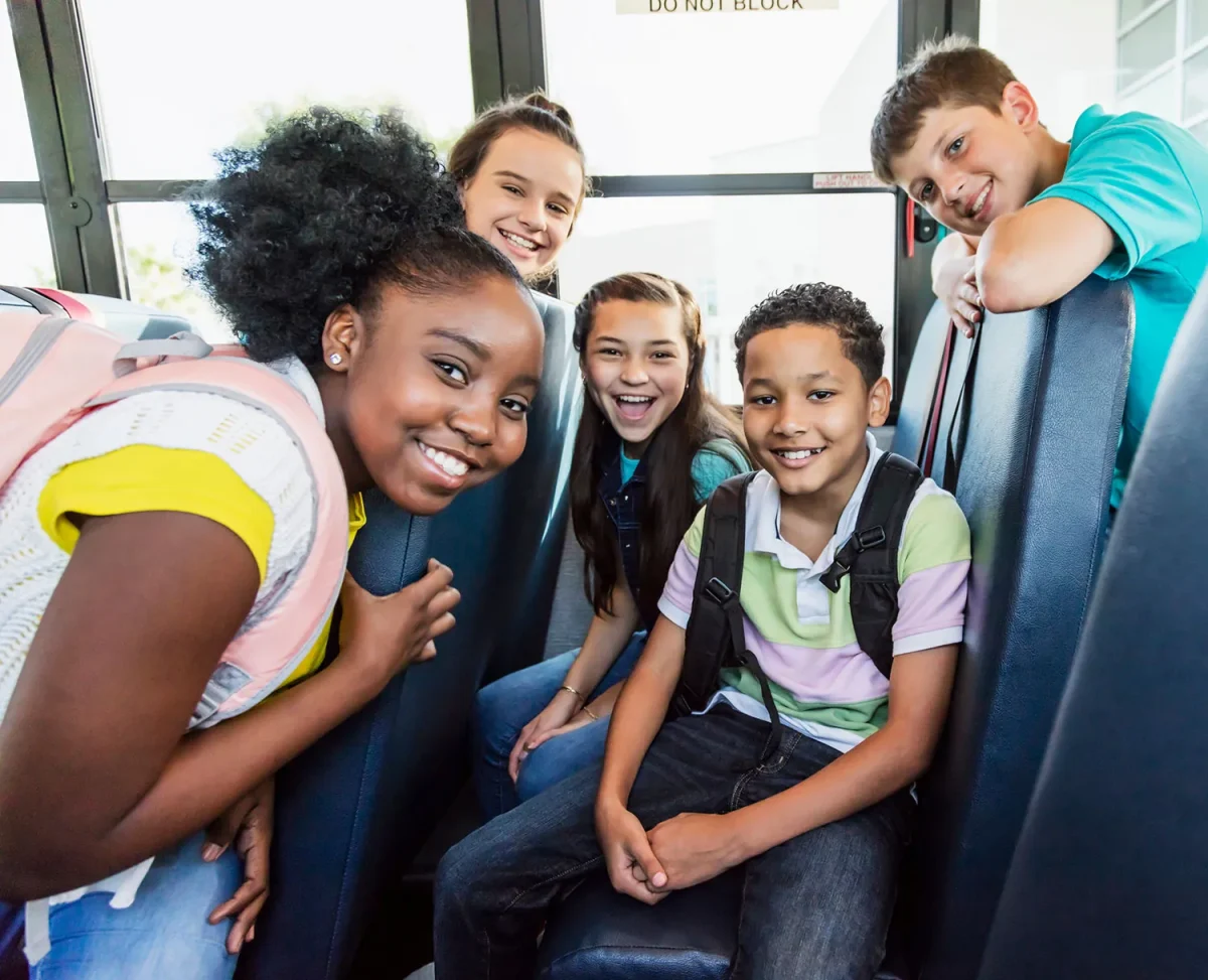 kids on a school bus smiling