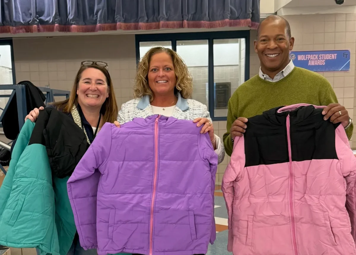 more volunteers holding up new coats