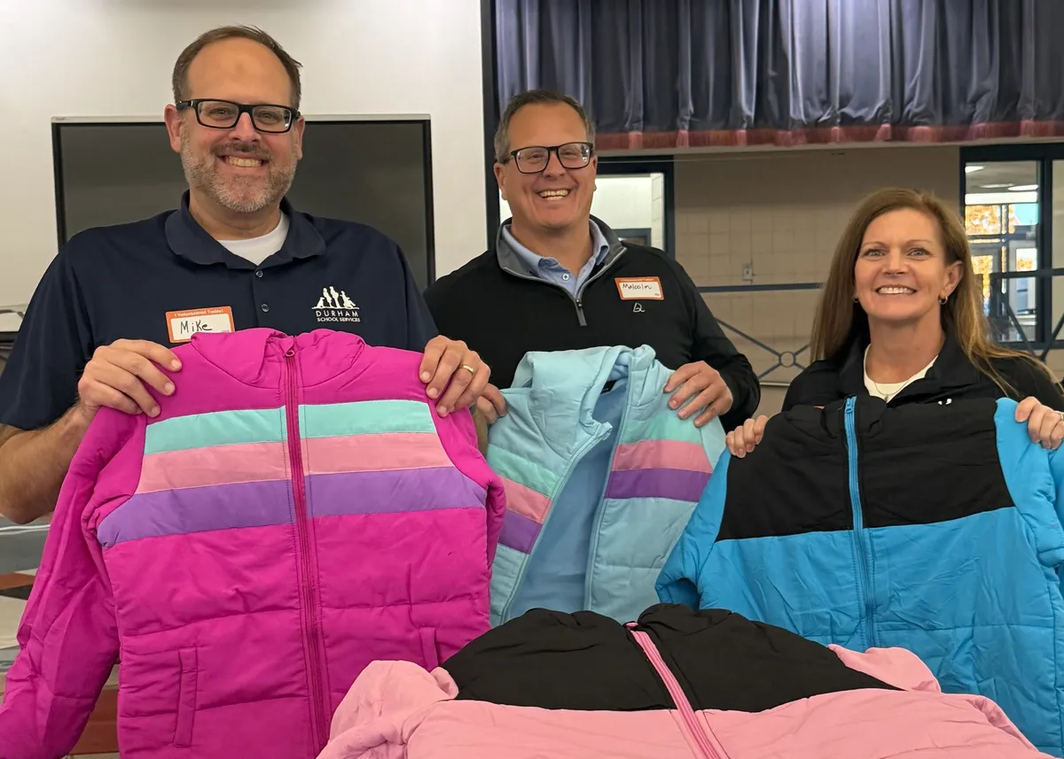 volunteers holding up new coats